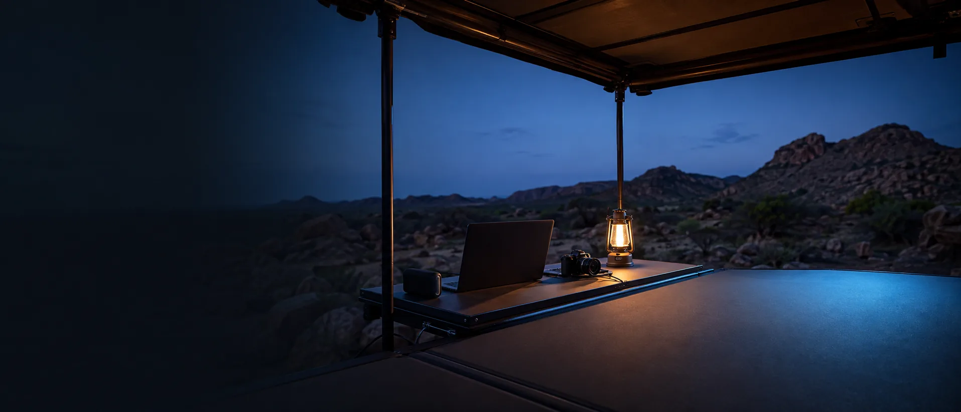 Sheltered outdoor workspace overlooking mountains at blue hour