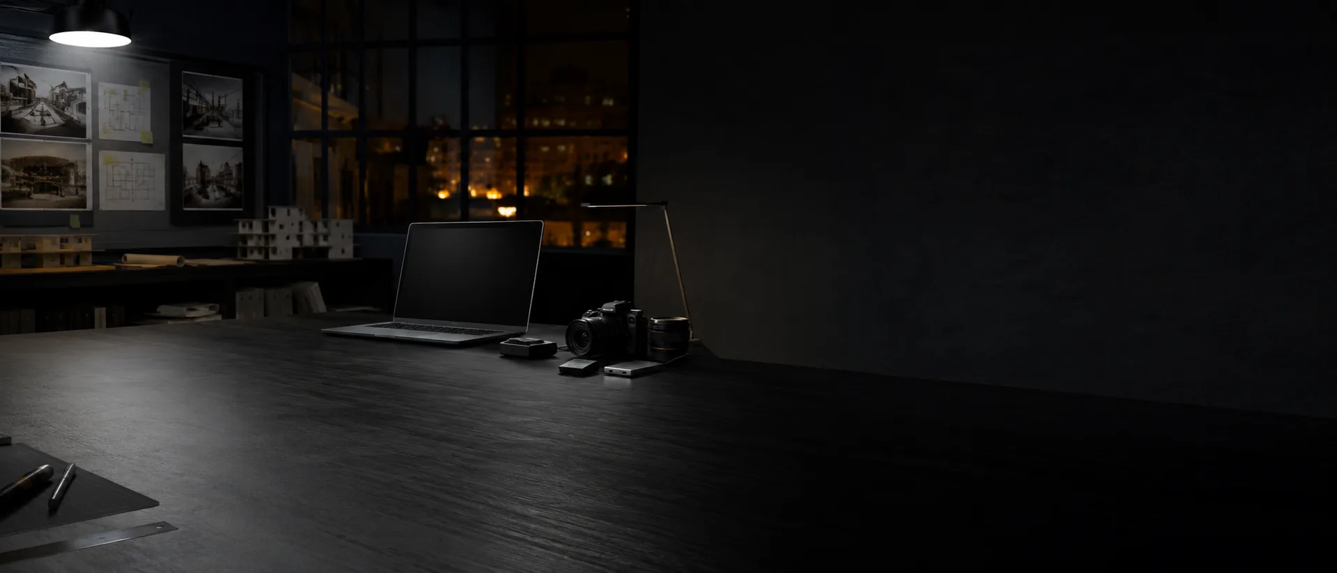 Dark professional studio with a laptop and camera arranged on a work surface